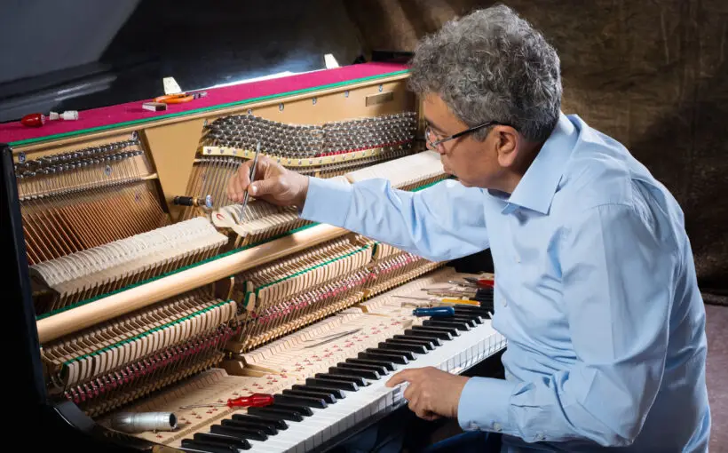 Instrument technician tuning a piano.